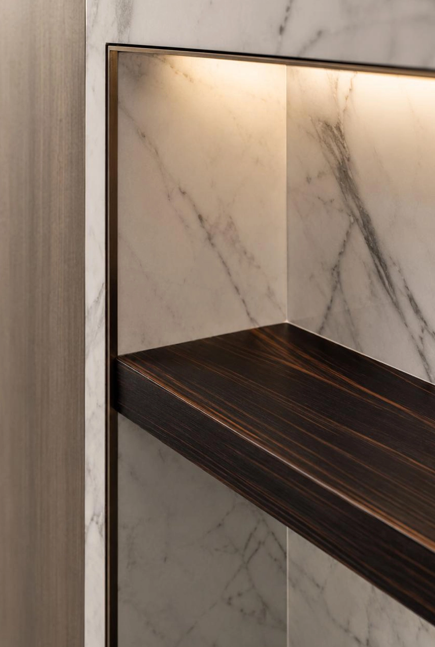 X4 Design and Build illuminated recessed shelf detail with marble wall panel, warm hidden LED lighting, dark wood shelf, slim frame, and luxury fit-out finishing